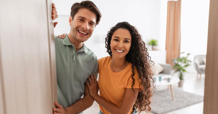 Immobilienbesichtigung Ein Pärchen öffnet die Haustür und empfängt Kaufinteressenten zur Immobilienbesichtigung | Immobilienbesichtigung