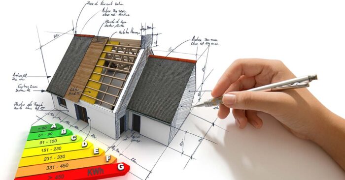 Eine Hand zeichnet auf weißem Untergrund ein Haus mit Effizienzklassen - Immobiliensanierung