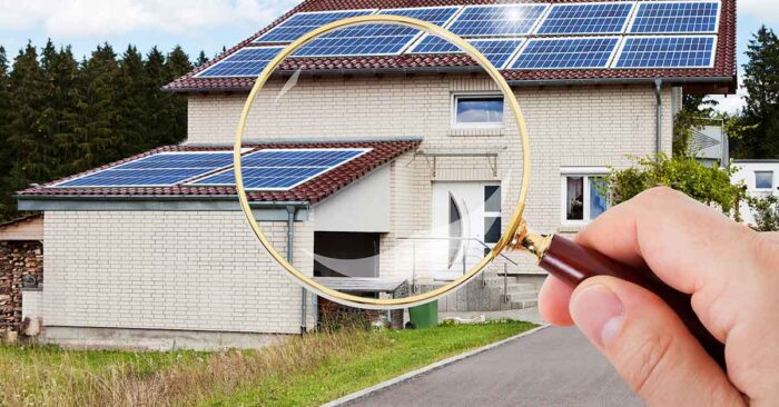 Suchauftrag Eine Hand mit Lupe vor einem Haus mit Garage - Suchauftrag