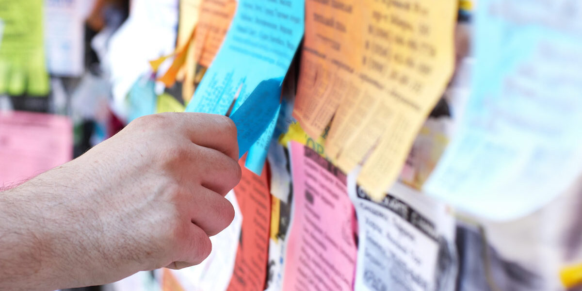 Ohne Suchportal zur neuen Immobilie ein schwarzes Brett mit Post-its und Sticky Notes