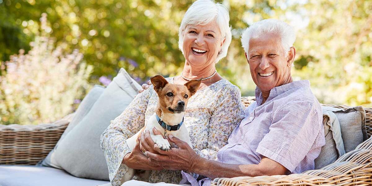 Wohnen im Alter Ein Seniorenpaar mit Hund freut sich