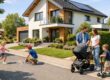 Modernes Einfamilienhaus in einer ruhigen, familienfreundlichen Wohngegend, gepflegte Vorgärten, breite saubere Straße, spielende Kinder auf dem Gehweg, junge Familie mit Kinderwagen vor dem Haus, viel Grün, Bäume und ein kleiner Spielplatz im Hintergrund. Lage Immobilienkauf