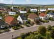 Luftaufnahme einer Wohnstraße mit Einfamilienhäusern und Preisangaben als Beispiel für das Vergleichswertverfahren bei Immobilien. | Vergleichswertverfahren