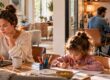 Familie im Homeoffice: Mutter arbeitet am Laptop, Kind macht Hausaufgaben und Vater nimmt an einer Videokonferenz teil – Homeoffice-Boom.